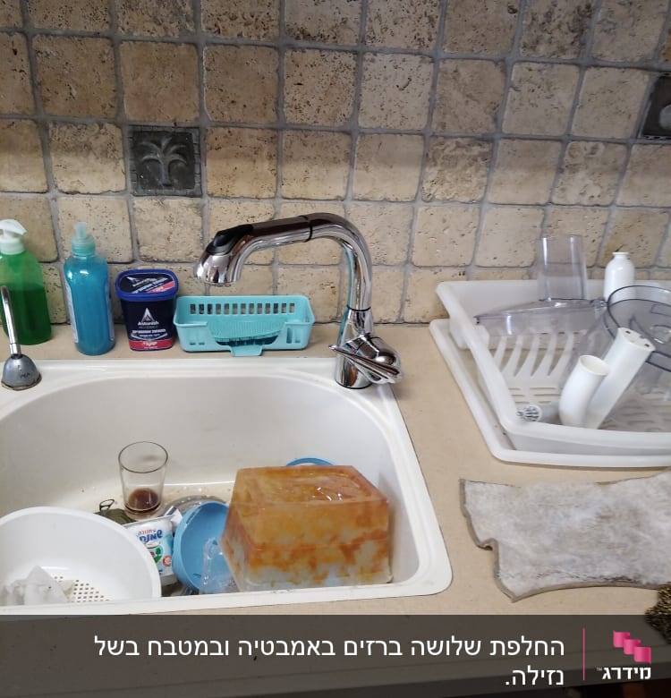 כיור מטבח עם ברז נירוסטה וכלים מלוכלכים